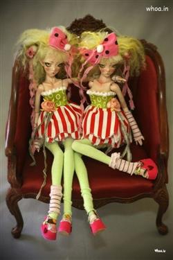 barbie doll twins sitting on a chair