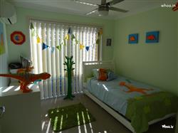 Kids Room with Delightful Dinosaur Theme of Bed cover with white,green and orange color Dinosaur