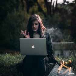 A girl using laptop and smoking cigrette Hd Images