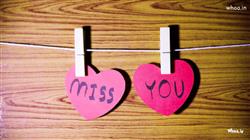 Image of I miss you on two heart shape paper is hanging on a string