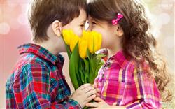 The HD image of two children, they kiss each other and give a beautiful yellow flowers