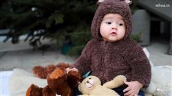 Cute Child Baby Is Wearing Brown Woolen Knitted Dr