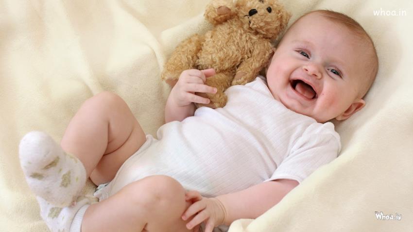 Smiling Cute Baby Toddler Is Lying Down On White Cloth Dress